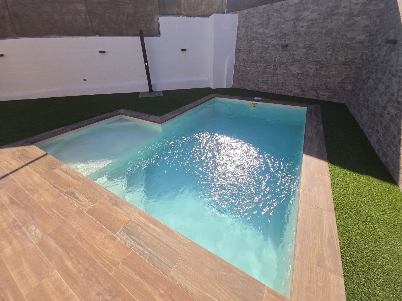 Piscina de obra nueva construida por Kawi, integrada con tarima de madera